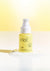 C ME - Vitamin C Serum by FRÉ - on a gel like surface with yellow background
